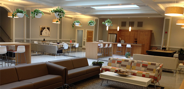 Common space with multiple seating areas and hanging plants.
